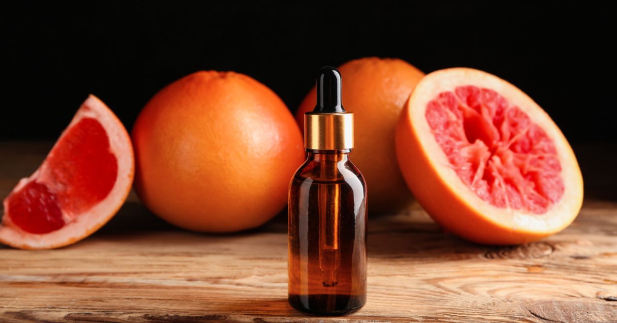 A dropper bottle of grapefruit oil on a wooden surface