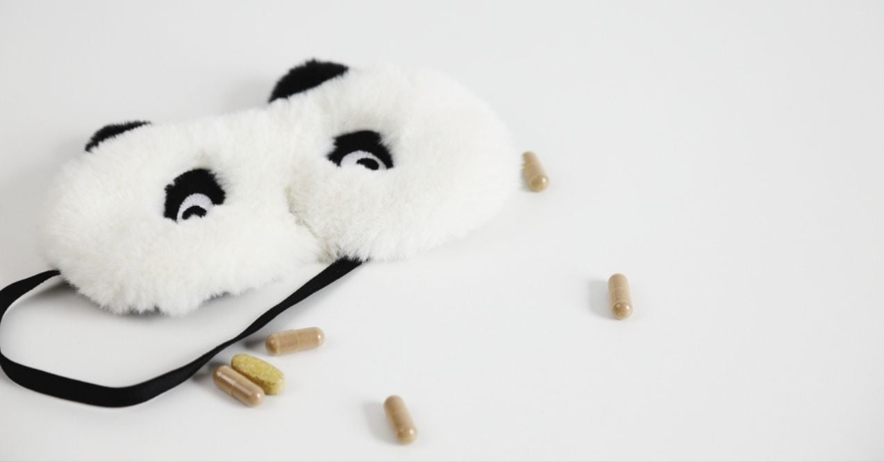 Fuzzy panda sleep mask with scattered pills