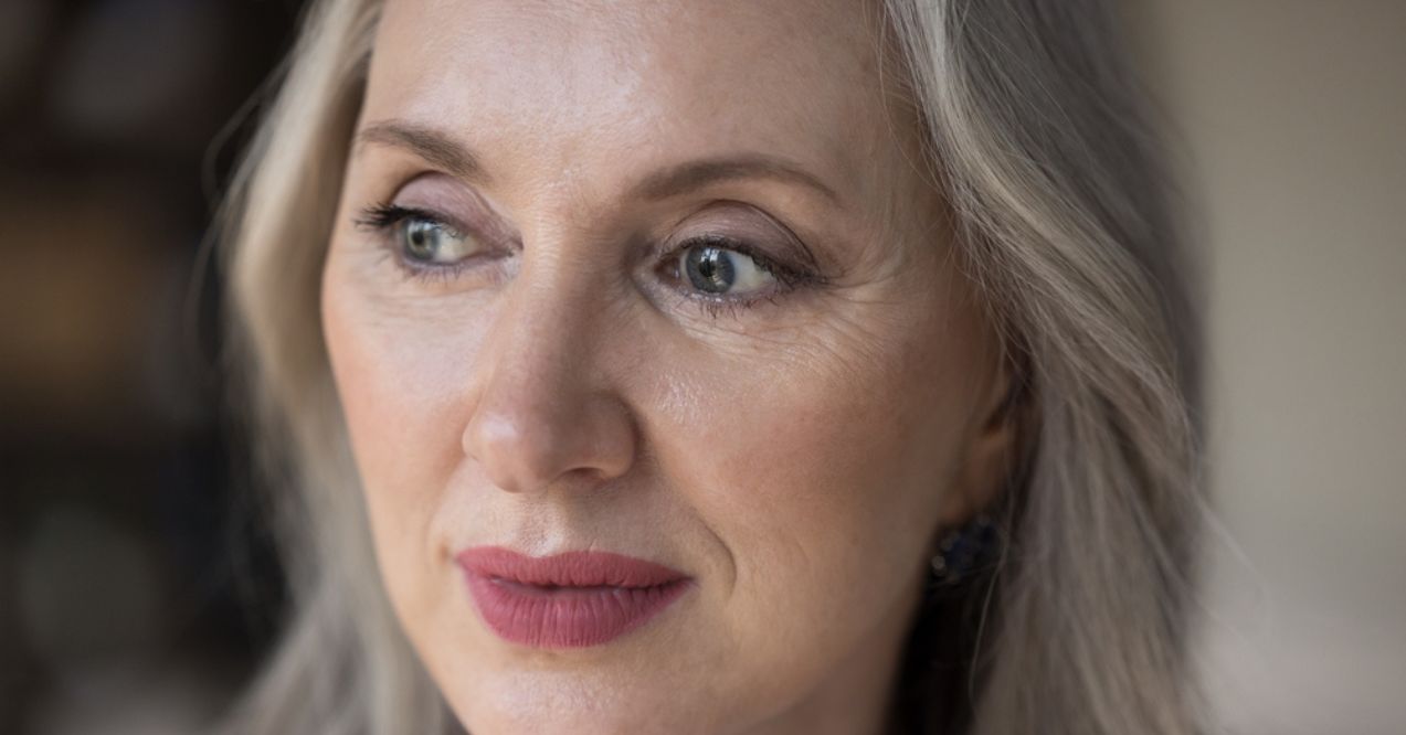 Close-up of a mature woman with visible wrinkles and gray hair