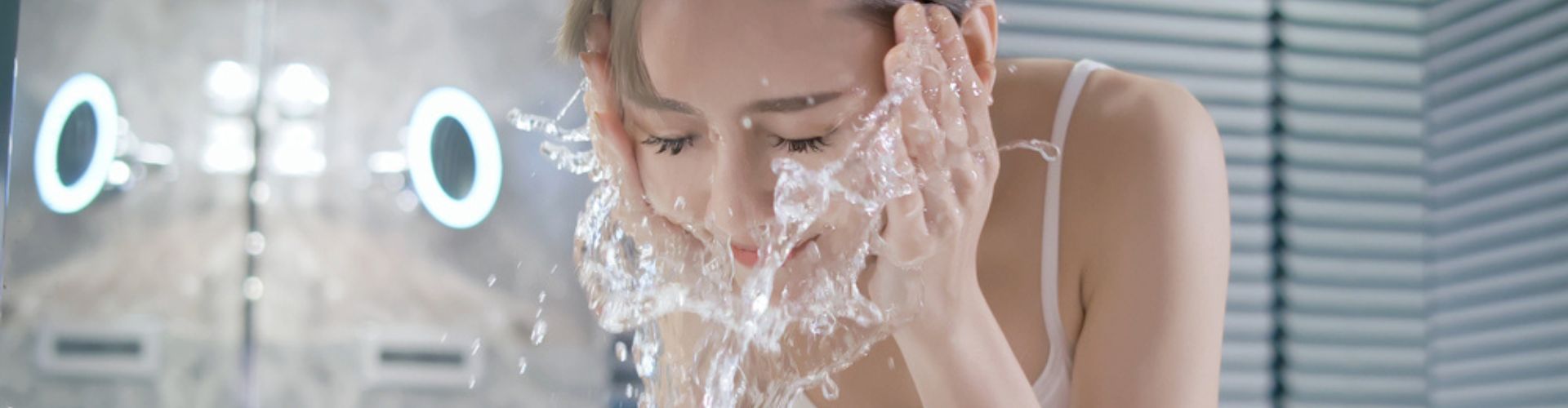 A woman washing her face with splashing water