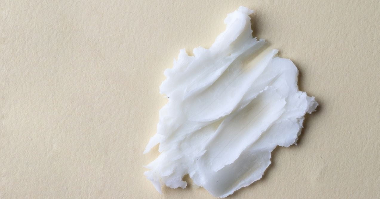 Close-up of a smear of white butter on a beige background