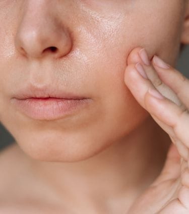 Close-up of a person touching their cheek