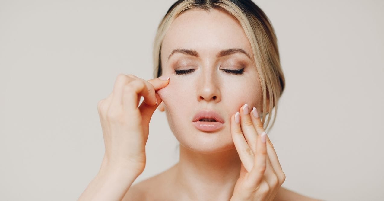 Person performing a facial massage to improve skin elasticity