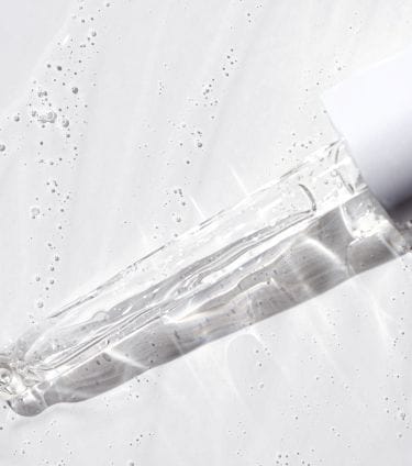 A dropper with clear liquid on a white background, explaining what is BHA in skin care.