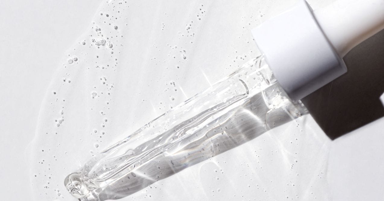 A dropper with clear liquid on a white background, explaining what is BHA in skin care.