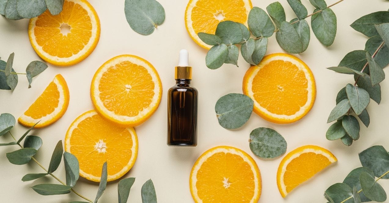 Vitamin C serum bottle with orange slices and eucalyptus leaves