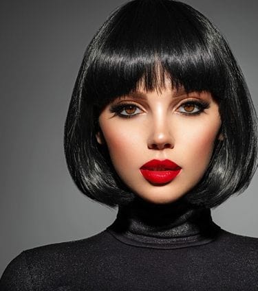 Woman with bold makeup and red lipstick posing confidently