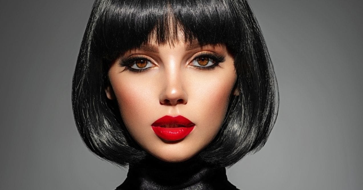 Woman with bold makeup and red lipstick posing confidently