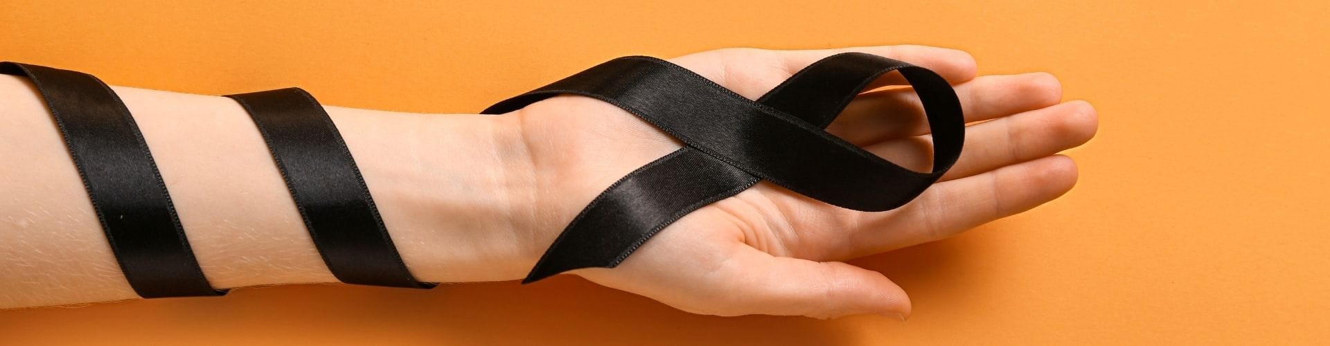 Black ribbon on a hand, symbolizing melanoma awareness