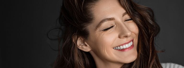 Woman smiling with visible smile lines