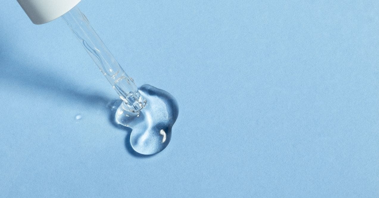 Clear serum dropper on blue background