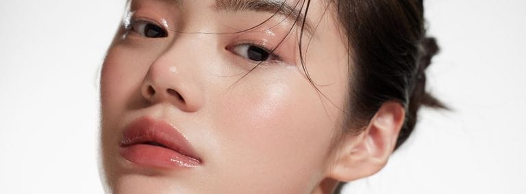 Close-up of woman with glass skin, showing smooth, shiny, and luminous complexion