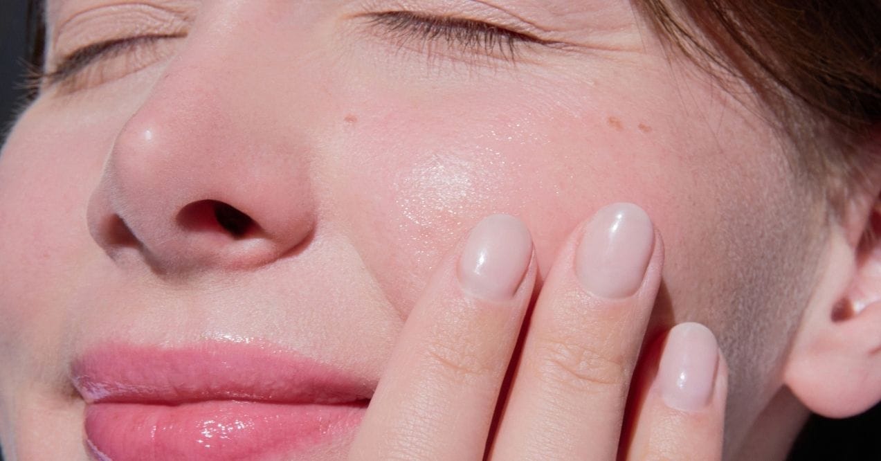 Close-up of a woman’s face with fresh, dewy skin in natural light