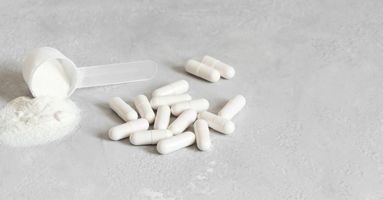 White collagen capsules and powder scoop
