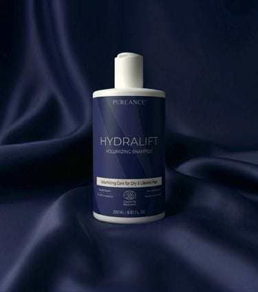 Pureance HydraLift Volumizing Shampoo bottle on dark blue satin fabric