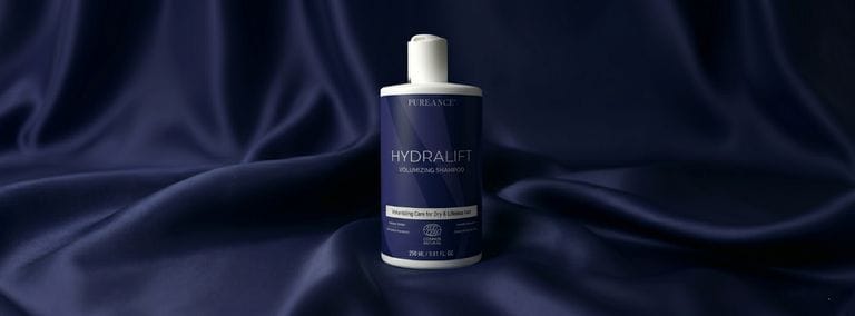 Pureance HydraLift Volumizing Shampoo bottle on dark blue satin fabric